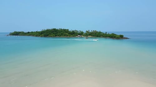 Schnellbootfahrt vor dem Hintergrund einer tropischen Insel an einem sonnigen Tag