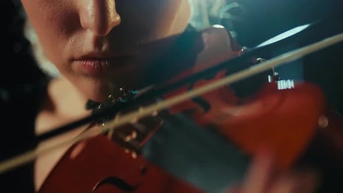 Enjoy Classical Music Closeup View of Violin and Female Face in Darkness Charming Woman Musician