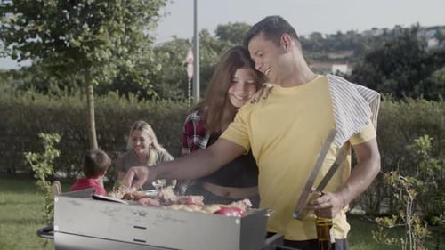 Happy Man Cooking Food on Barbecue Grill with Teenage Daughter