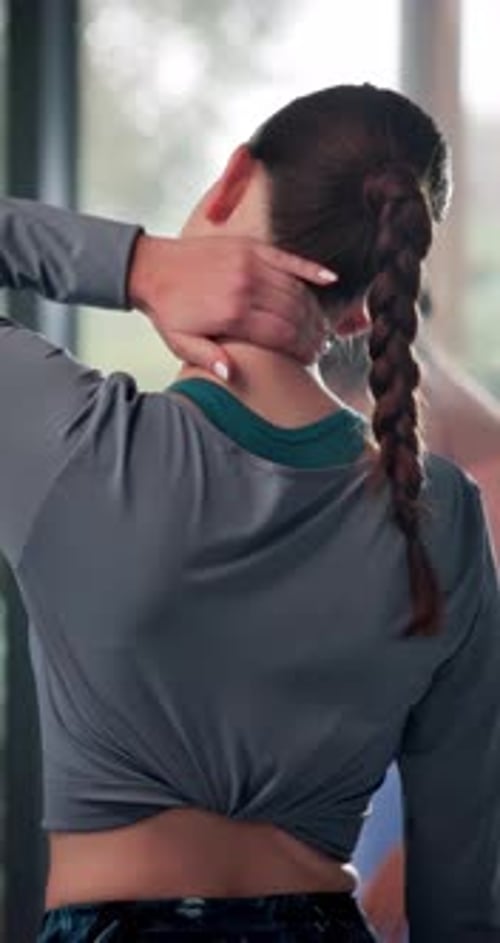 Woman Stretching Neck in Indoor Workout Area