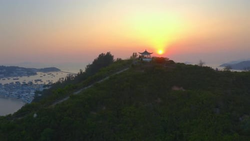 Foto de drone viajando para a esquerda acima de uma ilha próxima a uma pequena estrutura de observação asiática no