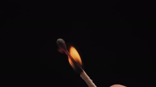 Burning match on a black background. Close up shot of igniting wooden match