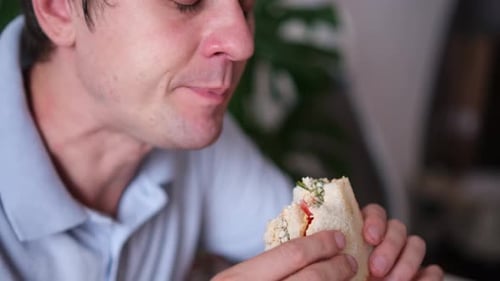 Man Eating Sandwich Indoors, Close Up