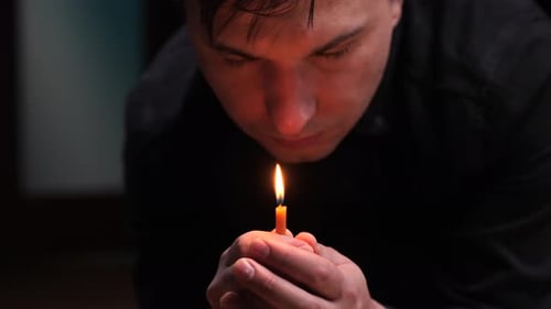 Priest Holding a Lit Candle During a Ceremony in the Church