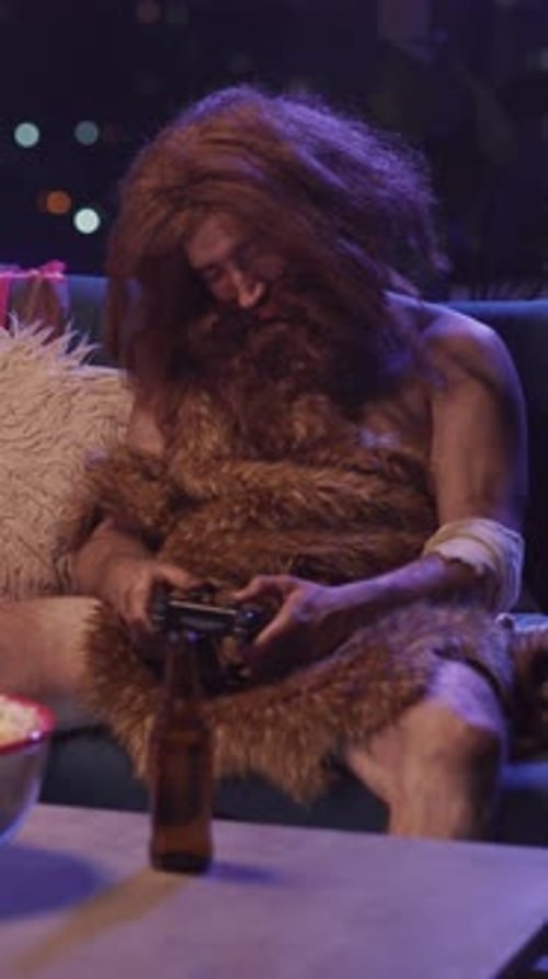 Sleepy and Funny Homo Sapiens Prehistoric Ancient Savage Wildman Human Sitting on Cocuh Watching TV