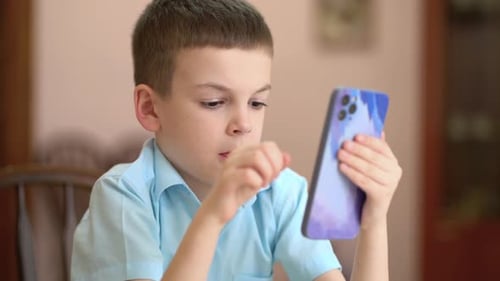 Focused Boy Using Smartphone Indoors