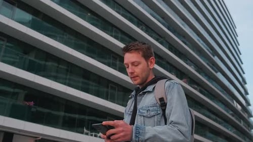 Young Handsome Man Using Smartphone Outdoor in a City Caucasian Guy Texting on His Mobile Phone at