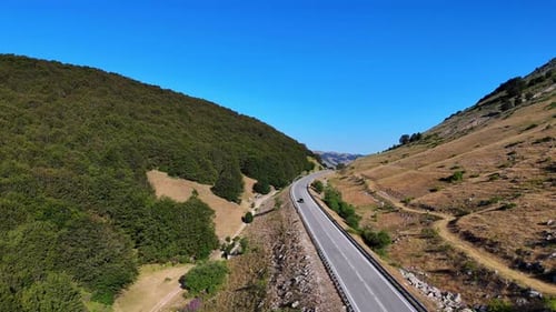 Black car driving through mountain forest road