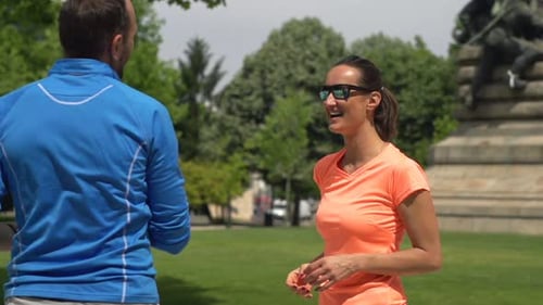 Sportive Couple Resting and Drinking Water in City Park Active