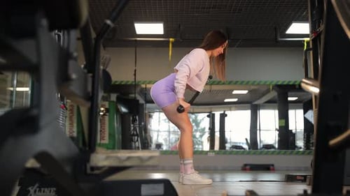Female Fitness Enthusiast Performing Deadlift Exercise in Gym