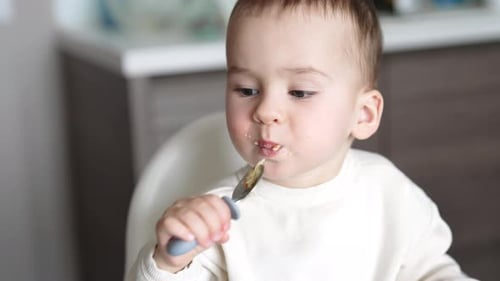 Toddler Eating Food with Spoon Close Up