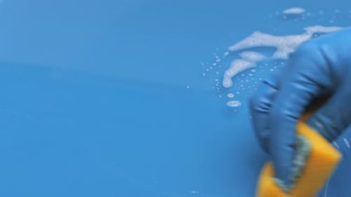 Cleaning Blue Surface with Sponge and Soap