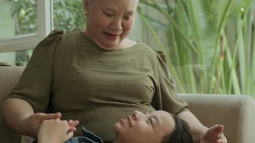 Grandmother and Grandchild Smiling Together on Couch