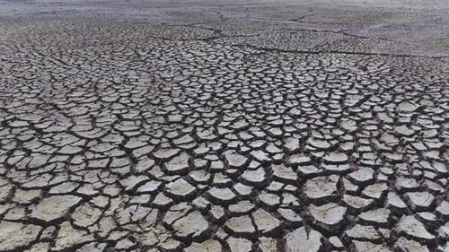 Dry and cracked gray soil ground during drought, viewed from above. top view. earthquake cracking ho