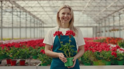 Woman Holding Flowers in Greenhouse