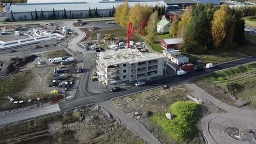 Aerial pulls back from concrete building under construction in Finland