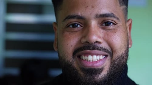One happy latin South American young man looking at camera smiling. Tight close-up face of 20s