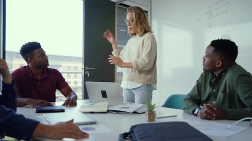 Asian businessman showing hand and smiling young team of colleagues making good business discussion