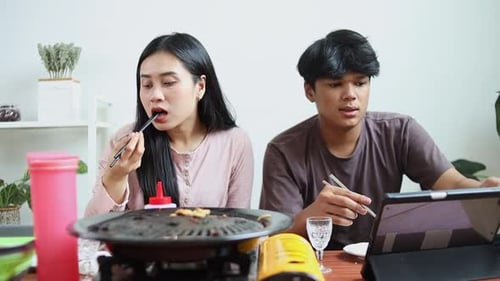 Une femme asiatique souffrant d'étouffement ou d'étouffement en mangeant un barbecue coréen et son amie donnant un verre W