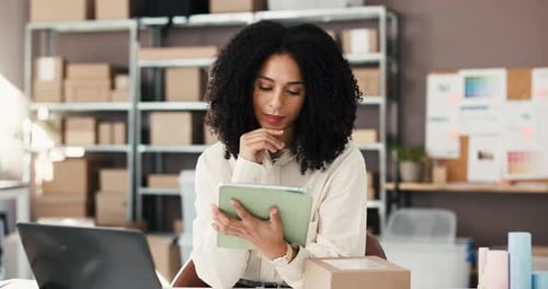 Woman Using Tablet in Box-Filled Workplace