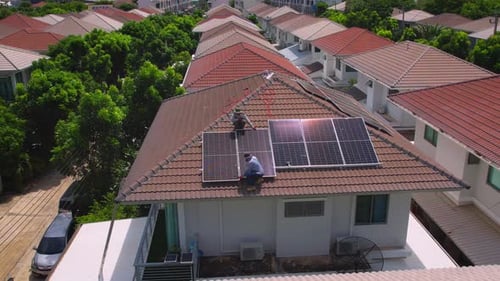 Drone view of engineer worker installed solar panels on roof of house.