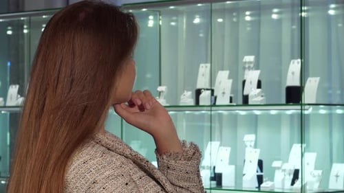 Joyful Young Woman Selecting Exquisite Jewelry in a Luxury Store