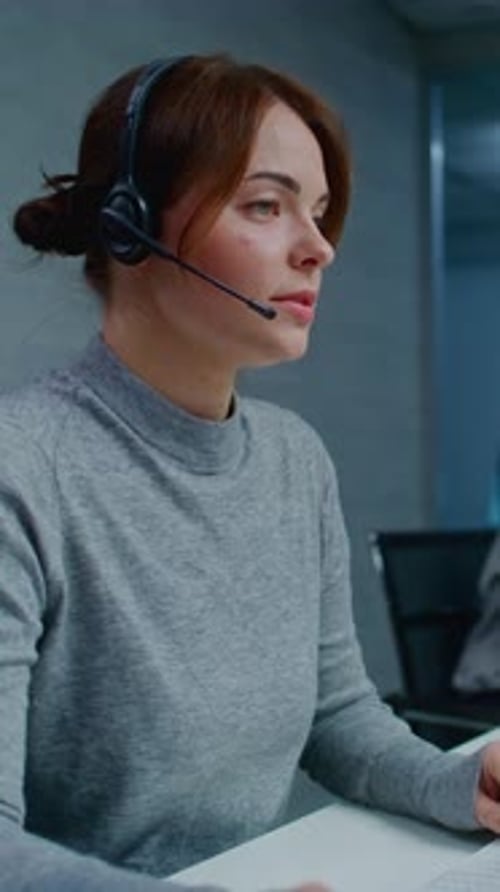 Woman with Headset Working at Computer in Office