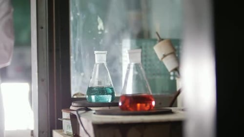 A Young Women Heat of the Flasks in Medical Laboratory