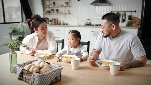 Family Enjoys Breakfast Together at Kitchen Table