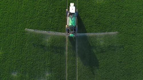 Farming Tractor Crop Sprayer on Green Field