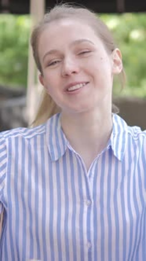 Online Video Chat by Young Woman Sitting in Cafe Terrace, Vertical Video