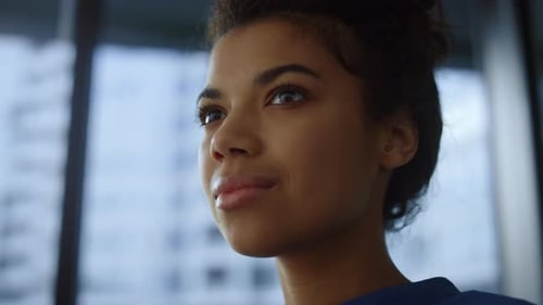 Dreamy african american businesswoman smiling enjoying coffee at work in office