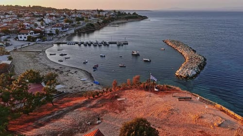 Vista aérea de un tranquilo pueblo costero en Grecia durante la hora dorada