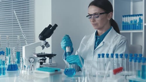 Scientist Performs Lab Work with Blue Liquid