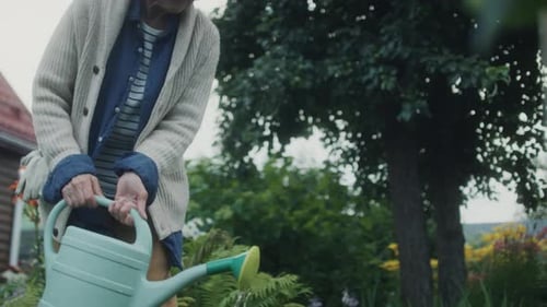 Senior Woman Watering Plants in Garden