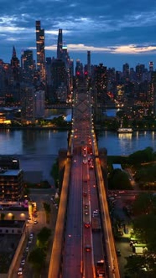 Stunning view of the city at coming evening. Queensboro Bridge in lights with cars passing along