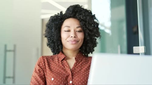 Happy young african american female employee finished work on laptop sitting in business office.