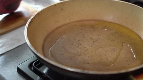Man cooking. A tasty piece of meat is sizzling in a hot pan