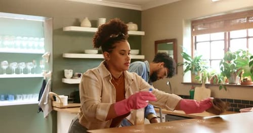Couple Cleaning Together in Sunny Kitchen