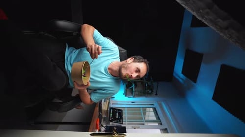Young Adult Eats Salad at Desk Indoors