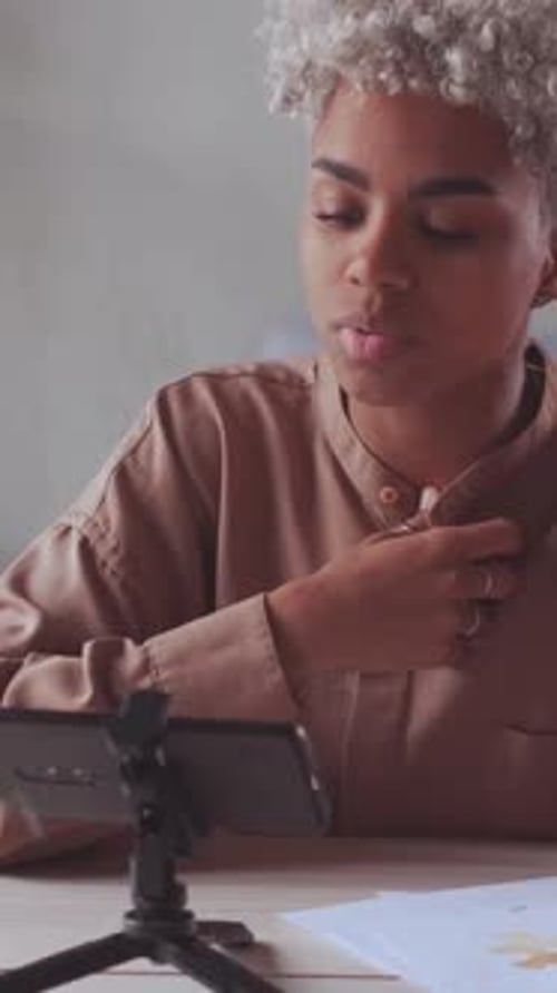 Stressed African American Blogger Recording Video on Her Mobile Tripod