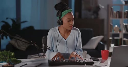 Woman Playing Synthesizer at Desk in Home