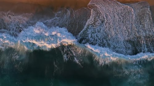 Zeitlupe schäumender Wellen, die bei schwacher Sonneneinstrahlung auf einen weißen Sandstrand zurollen