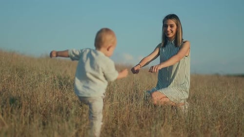 Child Runs to Woman in Field on Sunny Day