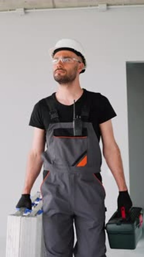 Builder in Uniform Walking with Tools on Construction Site Vertical Video