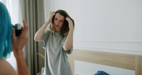 Young Women Taking Pictures in a Bedroom