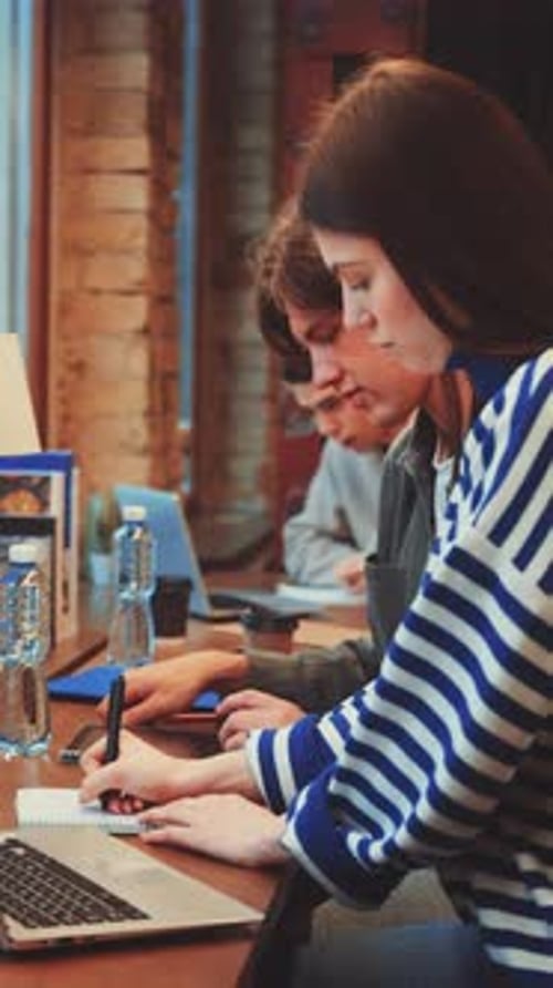 Young Adults Working Together With Laptop and Notebook