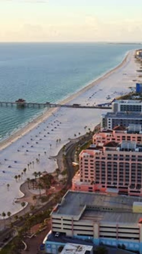 Beachfront hotels overlooking long sandy shoreline with ocean pier
