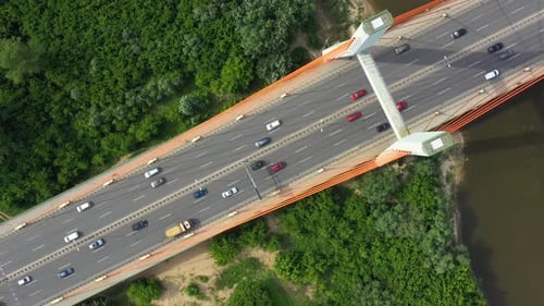 City car moving at highway bridge on background smooth river surface drone view