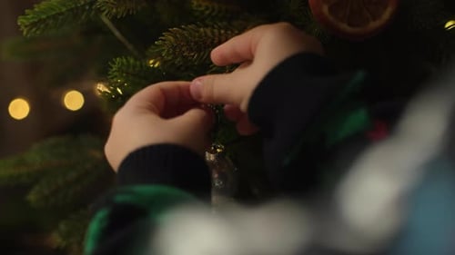 Child Decorating Christmas Tree With Ornament